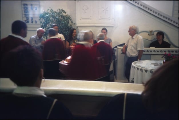 A dimly lit council chamber with representatives from different factions engaged in tense negotiations, symbolizing the political intrigue and power struggles that define 