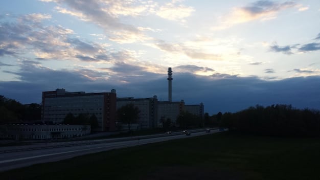 A panoramic view of a Nilfgaardian army marching across a vast plain, with the imposing architecture of their capital city visible in the distance, under a dark, ominous sky.