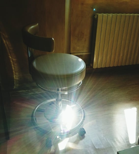 A dimly lit room with various traditional paranormal investigation equipment, such as EMF meters, EVP recorders, and temperature sensors, juxtaposed with a smartphone displaying a paranormal investigation app. This highlights the contrast between conventional methods and app-based approaches.