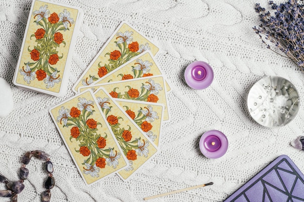 A close-up shot of tarot cards laid out on a table, with one card depicting a skeletal figure. The lighting is dramatic, emphasizing the darker aspects of the cards' symbolism. A hand hovers over the cards, casting a shadow.