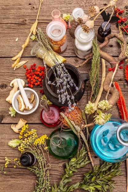 A diverse collection of crystals, herbs, and candles arranged on a wooden table, symbolizing the tools and ingredients used in various witchcraft practices.