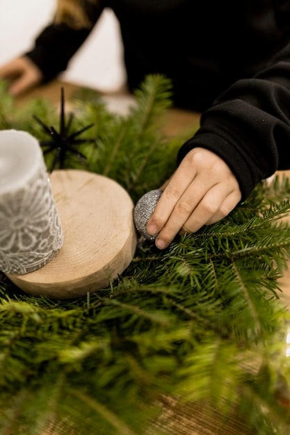 A close-up shot of hands carefully arranging crystals on a pentacle altar. The crystals are of various colors and sizes, reflecting ambient candlelight. The pentacle is made of wood and inlaid with silver symbols.