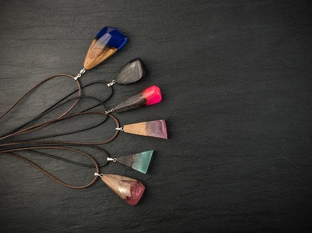 A selection of crystal pendants laid out on a velvet cloth, each with a different shape and color, showcasing various crystal options suitable for wearing as jewelry. The image is well-lit to highlight the unique characteristics of each crystal.