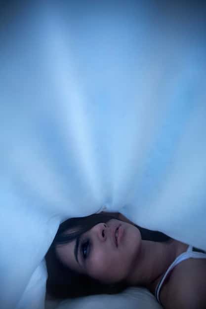 A person lying in bed with eyes closed, seemingly asleep, but with a faint, glowing outline of their astral body beginning to separate from their physical form. The room is dimly lit, creating an atmosphere of mystery and potential. The image visualizes the beginning stages of astral projection.