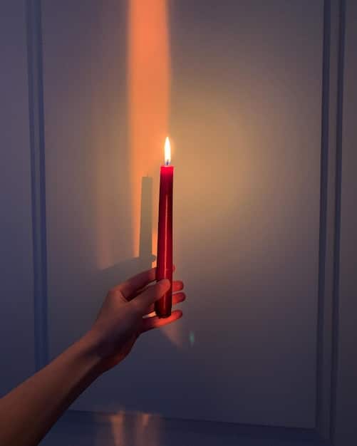 A person's hands are shown carefully lighting a single red candle on a small altar. The altar is adorned with crystals, herbs, and a small piece of paper with a written intention. The focus is on the act of lighting the candle, symbolizing the start of a magical working to Discover the Power of Candle Magic: 7 Colors and Their Specific Intentions for Manifestation with color association.