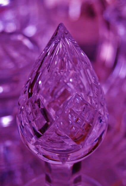 A close-up shot of a polished amethyst crystal, showcasing its vibrant purple color and intricate crystalline structure. The crystal is held in a person's hand, suggesting a connection and mindfulness. The background is blurred to keep the focus on the amethyst. The lighting is soft and diffused to enhance the crystal's natural beauty. This emphasizes the visual allure and calming properties of amethyst, one of The Top 5 Crystals for Reducing Stress and Anxiety in 2025 (and How to Use Them).