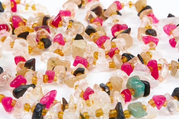 A close-up shot of various tumbled crystals labeled with their names (e.g., Rose Quartz, Amethyst, Clear Quartz). The crystals are arranged on a soft, neutral-colored fabric. The lighting is bright and clear, highlighting the different colors and textures of the crystals.