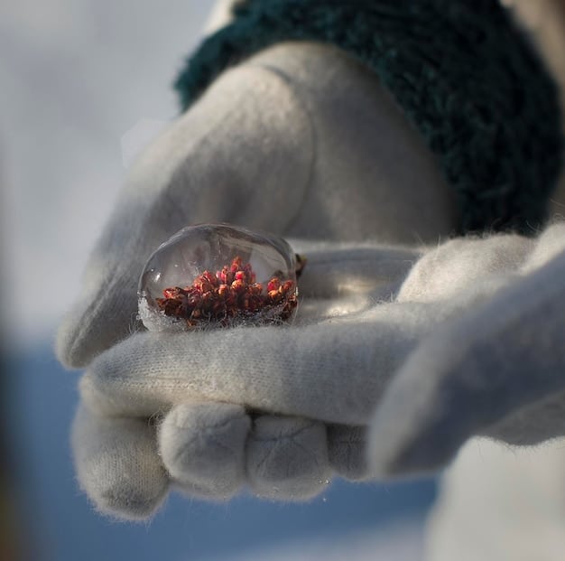 A close-up shot of a hand gently holding a sparkling garnet crystal under natural light, with a person meditating in the background, symbolizing the connection of Discover Your Birthstone Crystal: Harness Its Unique Power for Personal Growth through grounding and energy.