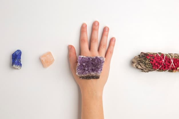 A hand is gently touching a chakra stone layout, with each crystal aligned to a specific energy center on the body. The setting is a softly lit room with yoga mats, symbolizing holistic wellness and how crystal healing may align with 'The Latest Research on Crystal Healing: What Science Says About Crystal Energy'.